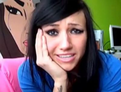 Canadian singer Lights looking serious with her hand on her face talking about a competition she's having for her pet spider Lance